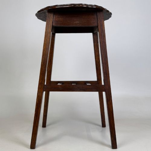 fig 4. A tall, dark oak Edwardian side table featuring a scalloped piecrust rim top, four splayed square legs, and a lower slatted shelf.