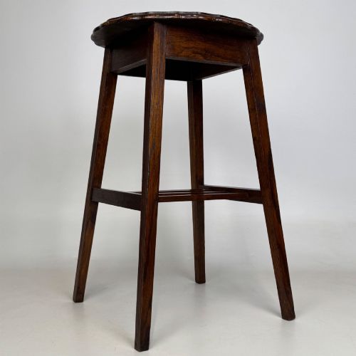 fig 5. A tall, dark oak Edwardian side table featuring a scalloped piecrust rim top, four splayed square legs, and a lower slatted shelf.