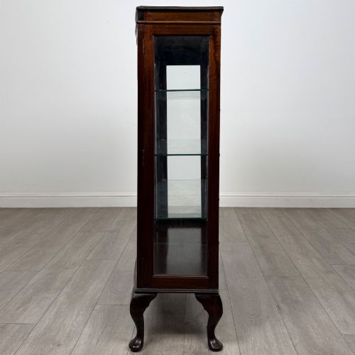 fig 3. An Edwardian mahogany display cabinet featuring astragal glazed doors with gothic arches, interior glass shelves, and cabriole legs.