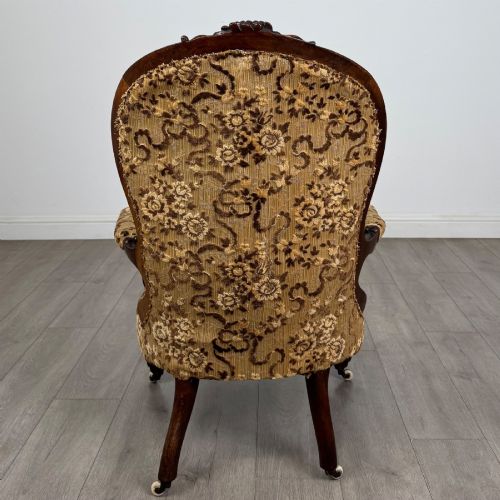 fig 3. A 19th-century Victorian open armchair constructed from carved walnut wood and upholstered in a patterned gold and brown velvet fabric.