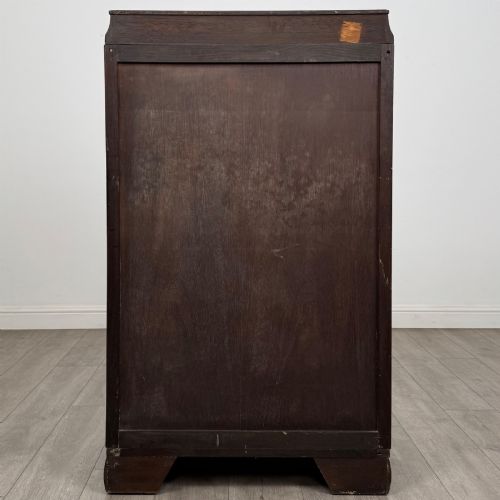 fig 5. A compact 20th-century oak fitted wardrobe with two doors featuring diagonal grain veneering, turned wooden knobs, and a stepped top profile.