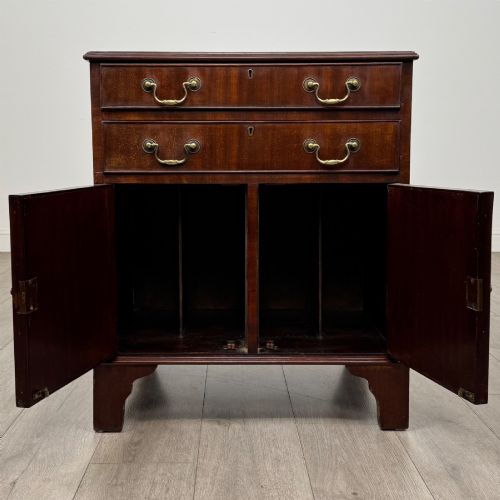 fig 1. A nineteenth-century dark mahogany small cupboard featuring two drawers with brass swan-neck handles above a double-door compartment set on bracket feet.