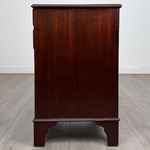 fig 3. A nineteenth-century dark mahogany small cupboard featuring two drawers with brass swan-neck handles above a double-door compartment set on bracket feet.
