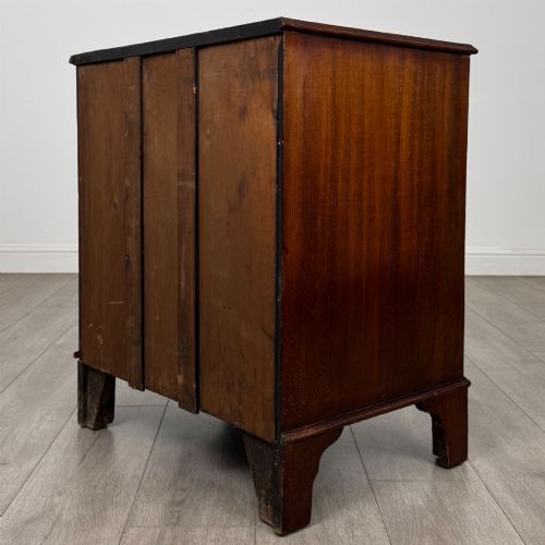 fig 6. A nineteenth-century dark mahogany small cupboard featuring two drawers with brass swan-neck handles above a double-door compartment set on bracket feet.