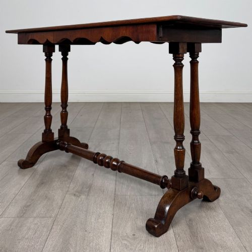 fig 1. A 19th-century Victorian mahogany side table featuring a rectangular top with a scalloped apron, turned twin-column supports, a central turned stretcher, and curved feet.