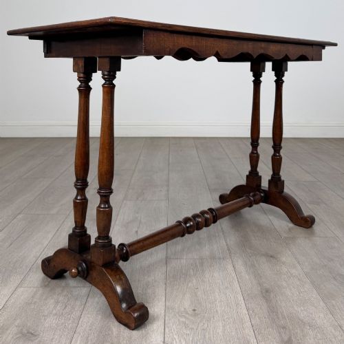 fig 3. A 19th-century Victorian mahogany side table featuring a rectangular top with a scalloped apron, turned twin-column supports, a central turned stretcher, and curved feet.