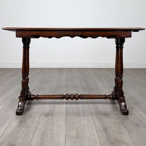 fig 4. A 19th-century Victorian mahogany side table featuring a rectangular top with a scalloped apron, turned twin-column supports, a central turned stretcher, and curved feet.