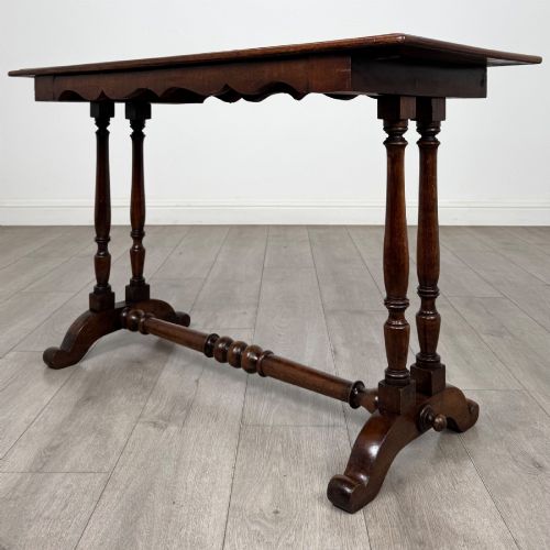 fig 5. A 19th-century Victorian mahogany side table featuring a rectangular top with a scalloped apron, turned twin-column supports, a central turned stretcher, and curved feet.