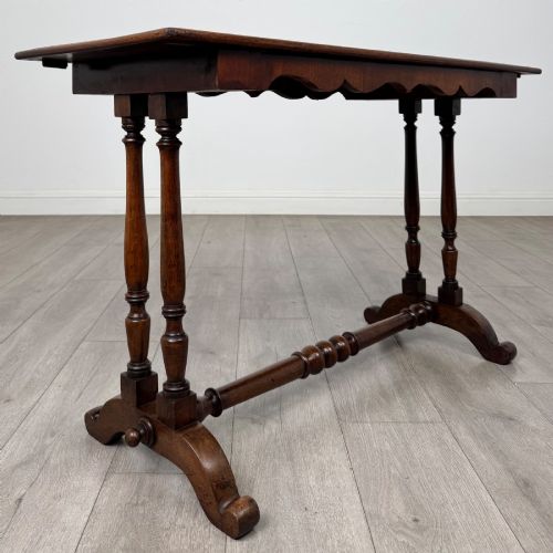 fig 7. A 19th-century Victorian mahogany side table featuring a rectangular top with a scalloped apron, turned twin-column supports, a central turned stretcher, and curved feet.