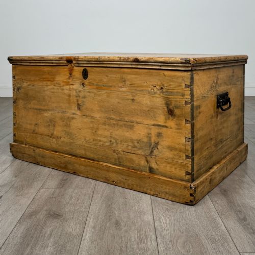 fig 1. A rectangular nineteenth-century rustic pine blanket box with visible hand-cut dovetail joints, a central keyhole escutcheon, and a moulded base.