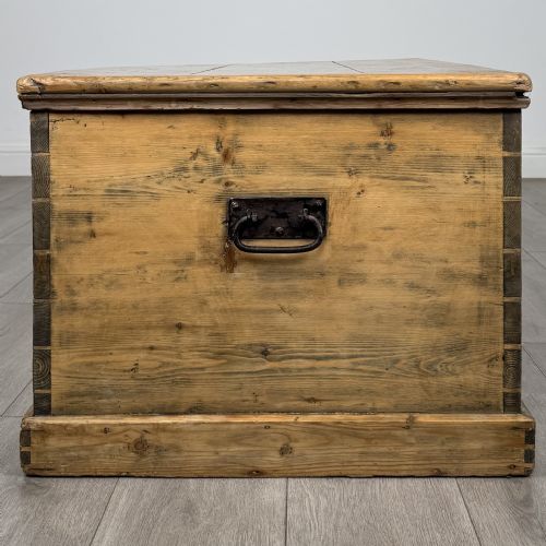 fig 2. A rectangular nineteenth-century rustic pine blanket box with visible hand-cut dovetail joints, a central keyhole escutcheon, and a moulded base.