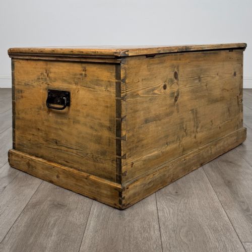 fig 3. A rectangular nineteenth-century rustic pine blanket box with visible hand-cut dovetail joints, a central keyhole escutcheon, and a moulded base.