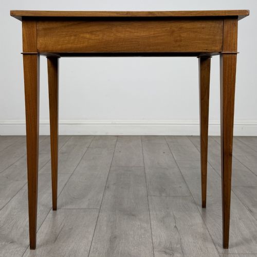 fig 4. An antique early 20th-century walnut side table with a flat rectangular top, plain frieze, and four square tapered legs.