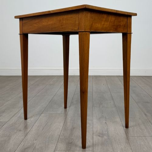 fig 5. An antique early 20th-century walnut side table with a flat rectangular top, plain frieze, and four square tapered legs.
