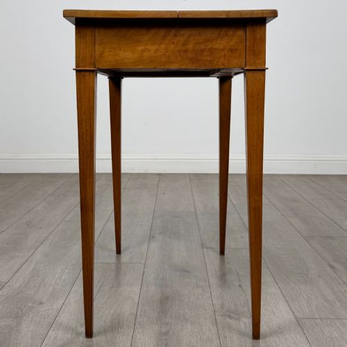 fig 6. An antique early 20th-century walnut side table with a flat rectangular top, plain frieze, and four square tapered legs.
