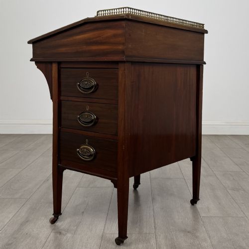 fig 2. An Edwardian mahogany Davenport desk featuring satinwood crossbanding, a top brass gallery rail, and castors on the base.