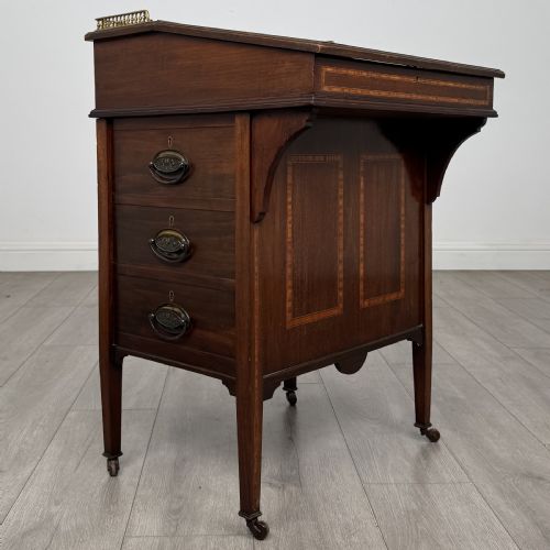 fig 6. An Edwardian mahogany Davenport desk featuring satinwood crossbanding, a top brass gallery rail, and castors on the base.