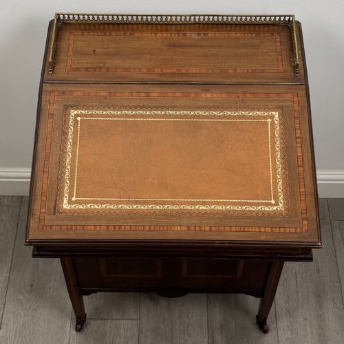 fig 8. An Edwardian mahogany Davenport desk featuring satinwood crossbanding, a top brass gallery rail, and castors on the base.