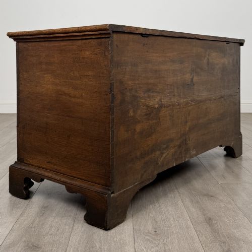 fig 3. An 18th-century Georgian golden oak mule chest featuring a hinged lid, two lower drawers with brass drop handles, shaped bracket feet, and the inscribed date 1789.