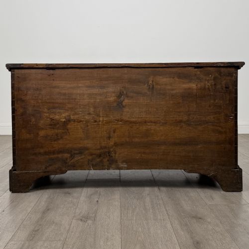 fig 4. An 18th-century Georgian golden oak mule chest featuring a hinged lid, two lower drawers with brass drop handles, shaped bracket feet, and the inscribed date 1789.