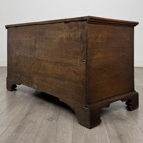 fig 5. An 18th-century Georgian golden oak mule chest featuring a hinged lid, two lower drawers with brass drop handles, shaped bracket feet, and the inscribed date 1789.