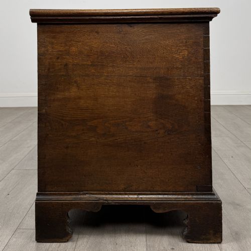 fig 6. An 18th-century Georgian golden oak mule chest featuring a hinged lid, two lower drawers with brass drop handles, shaped bracket feet, and the inscribed date 1789.