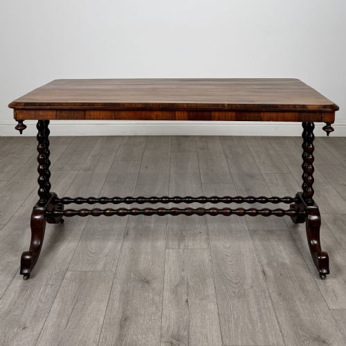 fig 1. A Victorian dark wood side table with a polished rectangular top, corner drop finials, double bobbin-turned legs, a twin bobbin stretcher, and splayed feet with brass castors.