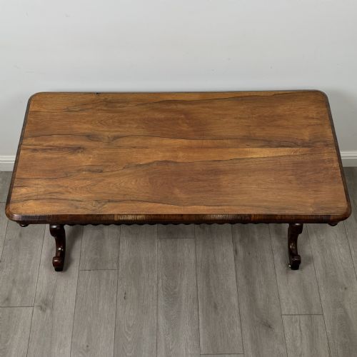 fig 3. A Victorian dark wood side table with a polished rectangular top, corner drop finials, double bobbin-turned legs, a twin bobbin stretcher, and splayed feet with brass castors.