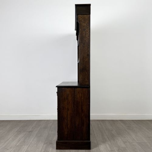 fig 3. A dark oak Welsh dresser featuring an upper plate rack with open shelves set above a two-drawer, two-door base cabinet.