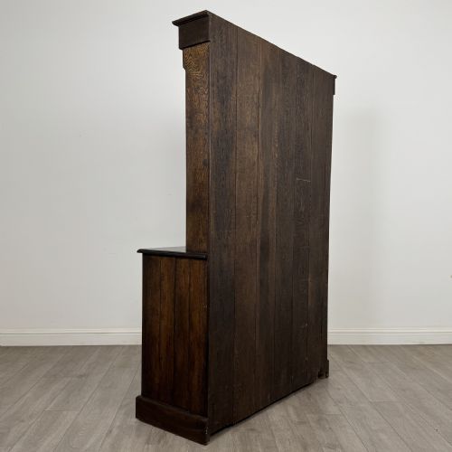 fig 4. A dark oak Welsh dresser featuring an upper plate rack with open shelves set above a two-drawer, two-door base cabinet.