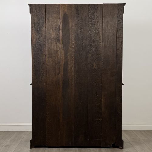 fig 5. A dark oak Welsh dresser featuring an upper plate rack with open shelves set above a two-drawer, two-door base cabinet.