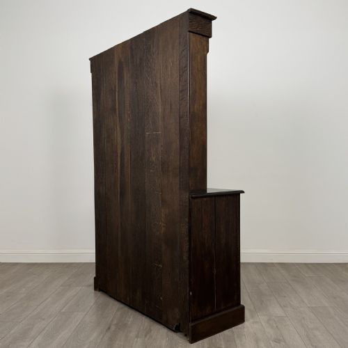 fig 6. A dark oak Welsh dresser featuring an upper plate rack with open shelves set above a two-drawer, two-door base cabinet.