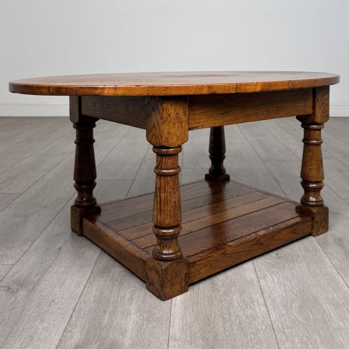 fig 3. An antique oval oak coffee table featuring four turned baluster legs and a solid lower undertier shelf.