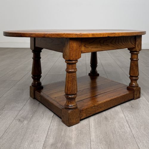 fig 7. An antique oval oak coffee table featuring four turned baluster legs and a solid lower undertier shelf.