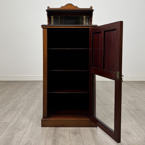 fig 1. An Edwardian inlaid mahogany cabinet featuring an upper mirrored gallery, two marquetry panels with shell motifs, and a glazed lower door section.