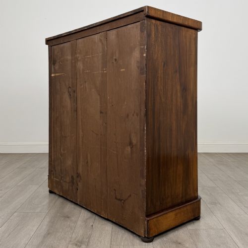fig 5. An Edwardian walnut chest of drawers featuring two short drawers over three long drawers with ornate brass handles.