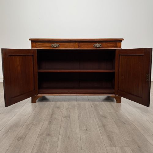 fig 1. A Victorian mahogany cupboard featuring two drawers with brass drop handles above two panelled doors, resting on bracket feet.