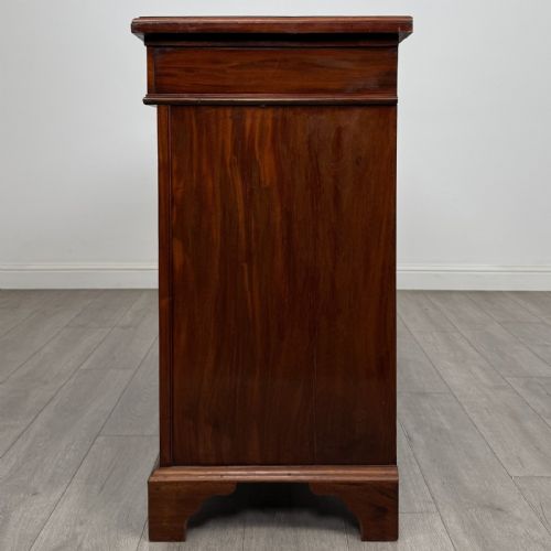 fig 3. A Victorian mahogany cupboard featuring two drawers with brass drop handles above two panelled doors, resting on bracket feet.