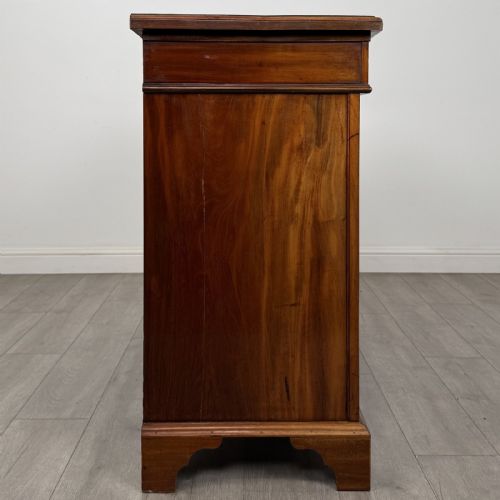 fig 7. A Victorian mahogany cupboard featuring two drawers with brass drop handles above two panelled doors, resting on bracket feet.
