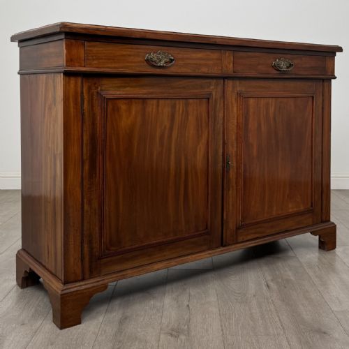 fig 8. A Victorian mahogany cupboard featuring two drawers with brass drop handles above two panelled doors, resting on bracket feet.