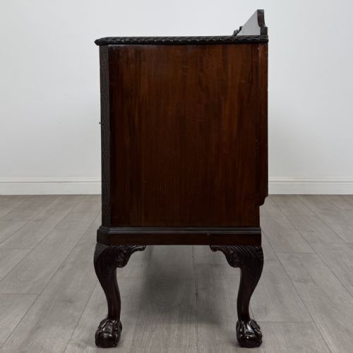 fig 4. An Edwardian mahogany sideboard featuring three central drawers flanked by two cupboard doors, resting on cabriole legs with claw and ball feet.