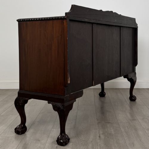 fig 5. An Edwardian mahogany sideboard featuring three central drawers flanked by two cupboard doors, resting on cabriole legs with claw and ball feet.