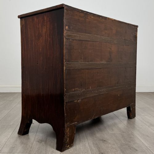 fig 3. An eighteenth-century Georgian bow-fronted mahogany chest of drawers with stringing inlay, oval brass handles, and splayed bracket feet.