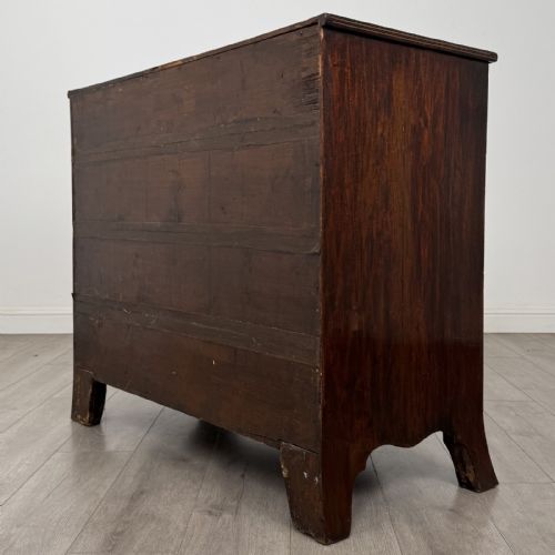 fig 5. An eighteenth-century Georgian bow-fronted mahogany chest of drawers with stringing inlay, oval brass handles, and splayed bracket feet.