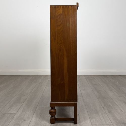fig 3. A warm brown antique oak display cabinet featuring two glazed doors with wooden glazing bars and squat turned legs.