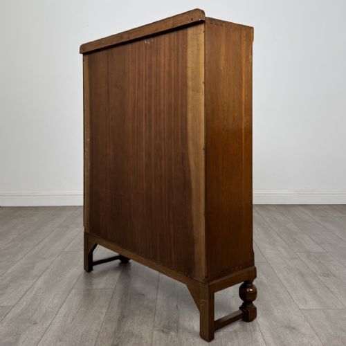 fig 6. A warm brown antique oak display cabinet featuring two glazed doors with wooden glazing bars and squat turned legs.