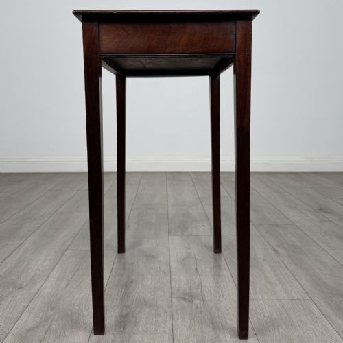 fig 2. An 18th-century Georgian mahogany side table with a single shallow drawer featuring a central circular brass pull, supported by four slim tapered legs.