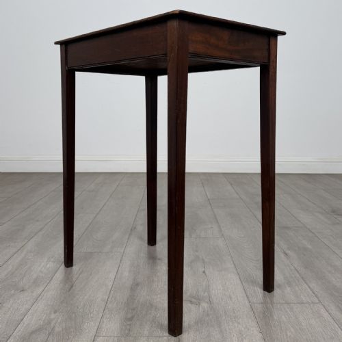fig 5. An 18th-century Georgian mahogany side table with a single shallow drawer featuring a central circular brass pull, supported by four slim tapered legs.
