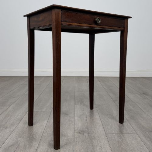 fig 7. An 18th-century Georgian mahogany side table with a single shallow drawer featuring a central circular brass pull, supported by four slim tapered legs.