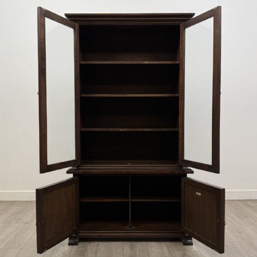 fig 2. A dark brown oak display cabinet featuring two glazed upper doors over two lower doors with carved geometric panels.